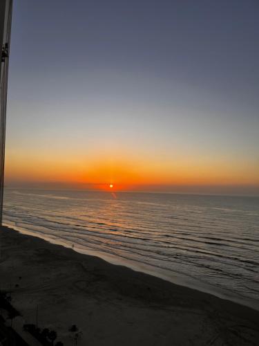 zachód słońca na plaży z oceanem w obiekcie Edifício Dubai temporada na Praia w mieście Solemar