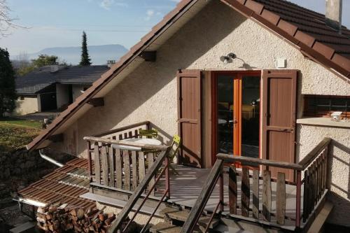 eine Veranda eines Hauses mit einer Holztür in der Unterkunft Appartement 55m2 dans maison in Gruffy