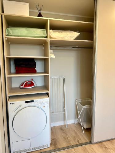 a laundry room with a washing machine in a closet at C a r p e D i e m in Ventspils