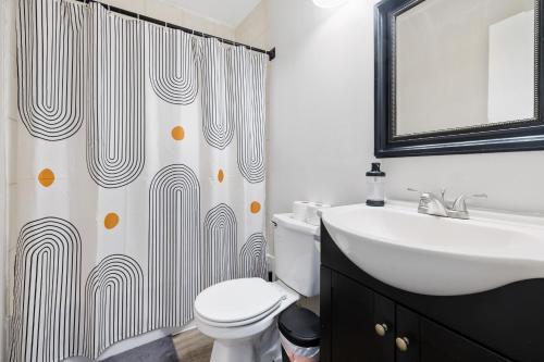 a bathroom with a sink and a toilet and a shower curtain at Step inside Central Living in Times Square in New York