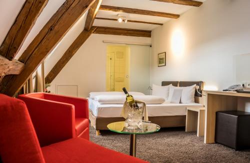 a room with a bed and a couch and a table at Hotel Hofgut Hohenkarpfen in Hausen ob Verena