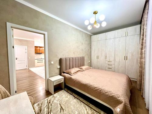 een slaapkamer met een bed en een spiegel bij Элитная квартира в ЖК “Отау сити” in Simkent