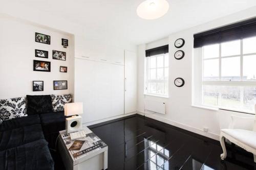a black and white living room with a couch and windows at Cosy Studio in Bethnal Green in London