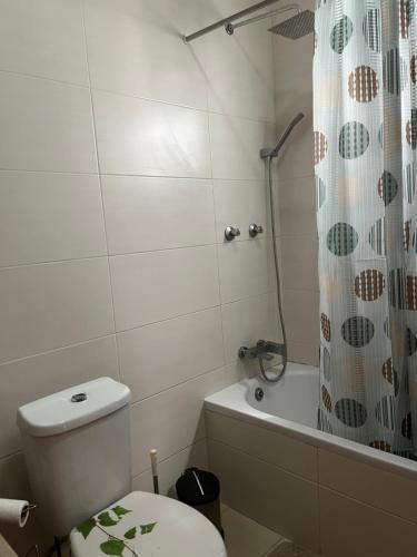 a bathroom with a toilet and a shower curtain at Nerys House in São Filipe