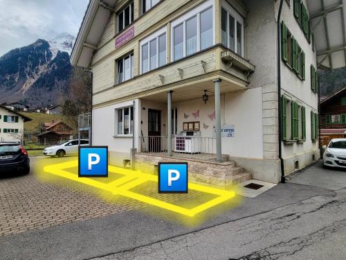 a house with two parking spaces in front of it at Mountain Holiday in Wimmis