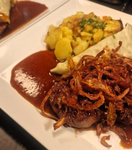 a plate of food with meat and potatoes and sauce at Boutique- und Businesshotel Herrenküferei in Markgröningen