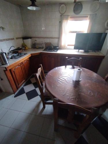 a kitchen with a wooden table with chairs and a sink at Ushuaia hospedaje in Ushuaia