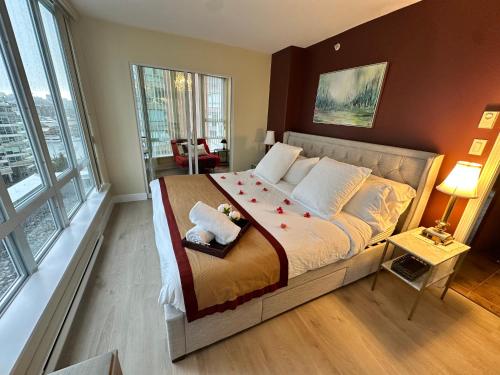 a bedroom with a large bed with red flowers on it at Penthouses of Beach Ave in Vancouver