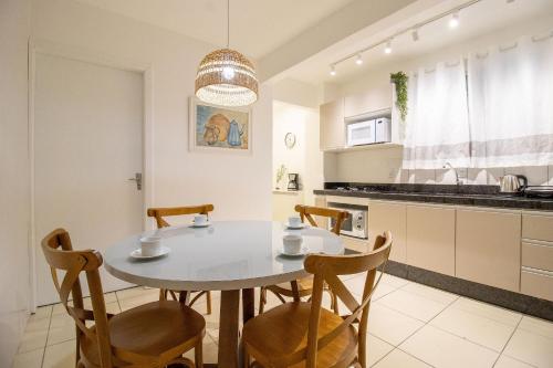 une cuisine avec une table et des chaises dans une cuisine dans l'établissement JOA24 - 2 Dorm, Totalmente Climatizado, Garagem, à Balneário Camboriú