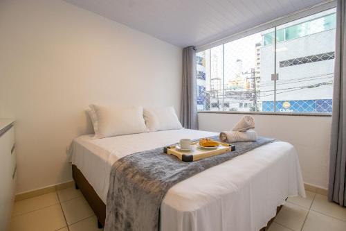- une chambre avec un lit et un plateau de nourriture dans l'établissement JOA24 - 2 Dorm, Totalmente Climatizado, Garagem, à Balneário Camboriú
