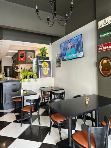 a restaurant with tables and chairs and a tv on the wall at Lolo Hotel Boutique in Mar del Plata