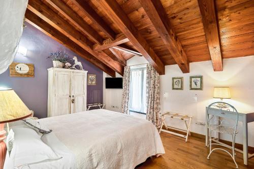 - une chambre avec un grand lit blanc et des plafonds en bois dans l'établissement Affittacamere La Collina Degli Ulivi, à La Spezia