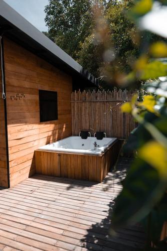 a hot tub in a backyard with a wooden fence at Rainbow Glamping in Abejorral