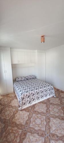 - une chambre avec un lit dans un dortoir doté de carrelage dans l'établissement Residencial Vitor Studio 1, à São José dos Pinhais