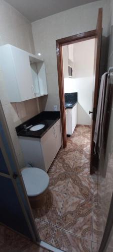 La salle de bains est pourvue de toilettes et d'un lavabo. dans l'établissement Residencial Vitor Studio 1, à São José dos Pinhais