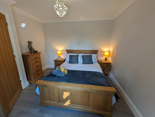 a bedroom with a large wooden bed with two lamps at Cottage in the Heart of Suffolk in Stowmarket