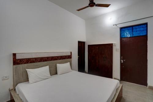 a bedroom with a white bed and a ceiling fan at OYO Sky Line in Ghaziabad