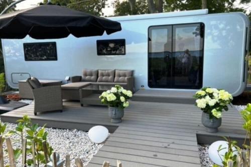 a living room with a couch and an umbrella at Dreamer Luxus-Caravan am Achterwasser, Lütow in Lütow
