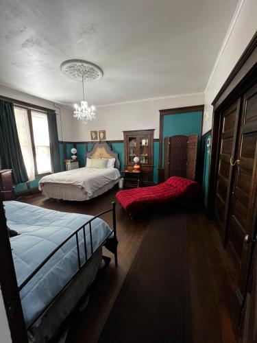 a bedroom with two beds and a chandelier at Bed and Breakfast Hearts Desire in Raton