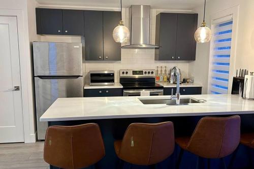 cocina con fregadero y barra con sillas en 1 bedroom w/ shared space, en Halifax