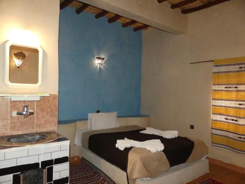 a hotel room with a bed and a sink at Auberge Sahara in Merzouga