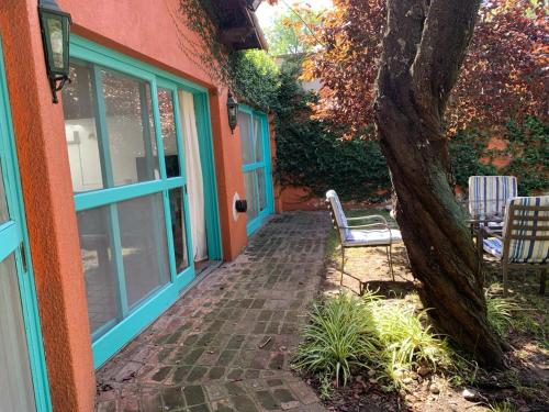 a porch of a house with a tree at Casa máximo confort con oficina in Campana