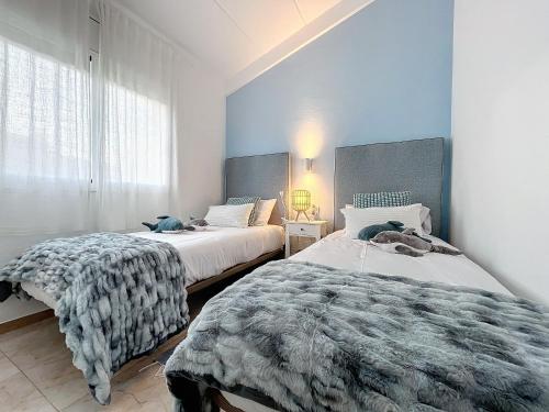 2 camas en un dormitorio con paredes azules en Mar Blau Estartit Rental, en L'Estartit
