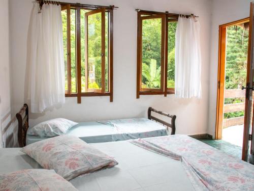 A bed or beds in a room at Recanto da Rose Guesthouse