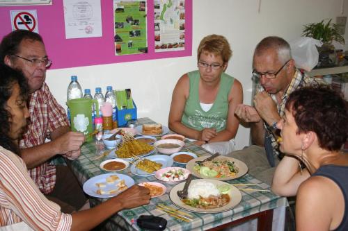 a group of people sitting around a table eating food at Manora Garden in Phangnga