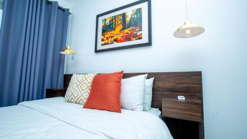 a bedroom with a bed with blue walls at Embasy Gardens by Rosy Apartments in Accra