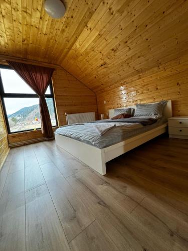 a bedroom with a bed and a large window at CABANA EDEN in Cîmpeni