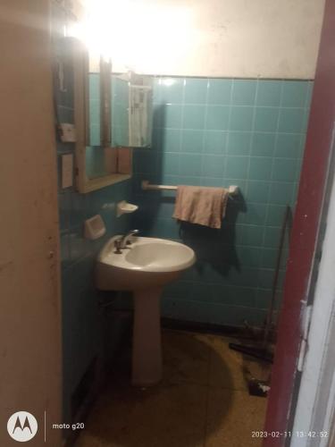a bathroom with a white sink and a blue wall at La Comuna in Mar del Plata