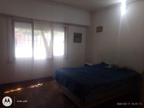 a bedroom with a blue bed and two windows at La Comuna in Mar del Plata