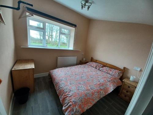 ein Schlafzimmer mit einem Bett und einem Fenster in der Unterkunft Redhouse Farm Cottage the most dog friendly place Ive ever stayed in Withernsea