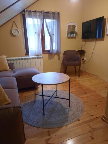ein Wohnzimmer mit einem Tisch und einem Sofa in der Unterkunft Apartment Dea in Kolašin