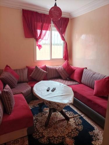 a living room with a red couch and a table at Al fajar2 in Alimadene