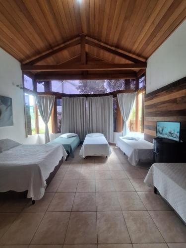 1 dormitorio con 2 camas en una habitación con techos de madera en Pousada ESQUINA DO ATLANTICO SUL en Tubarão