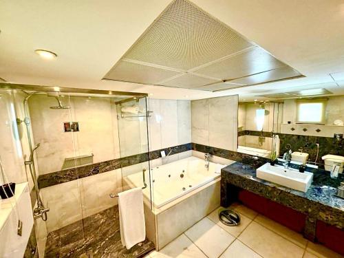 فندق كينغ سويتس في بيروت: حمام مع دش وحوض استحمام ومغسلة