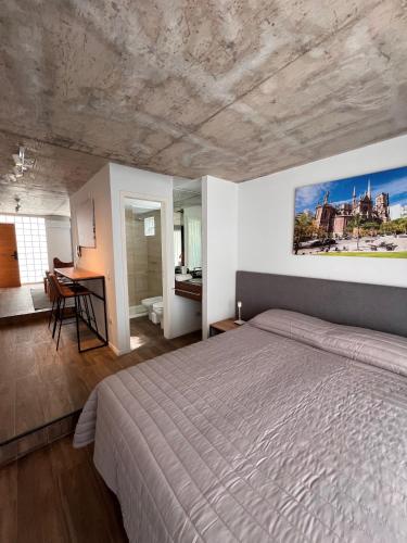 a bedroom with a large bed and a desk at Departamentos en Gral Paz a pasos de clínicas in Córdoba