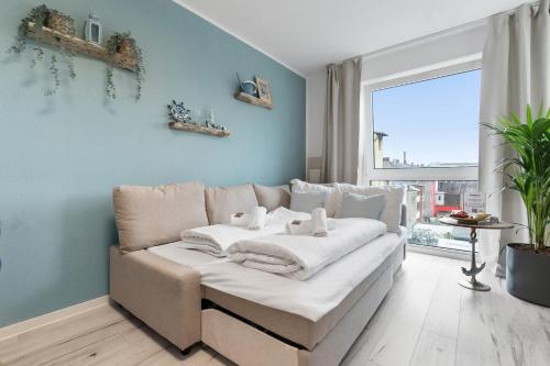 a living room with a couch and a large window at Federnest - Superior-2-Zimmer-Wohnung - Kingsize Boxspringbett - Home-Office mit Monitor - 11 Min Hbf in Duisburg