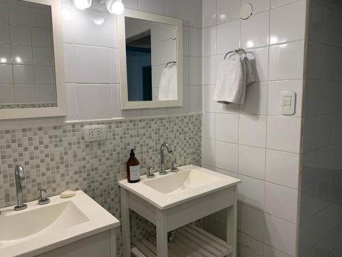 a white bathroom with two sinks and a mirror at Casa máximo confort con oficina in Campana