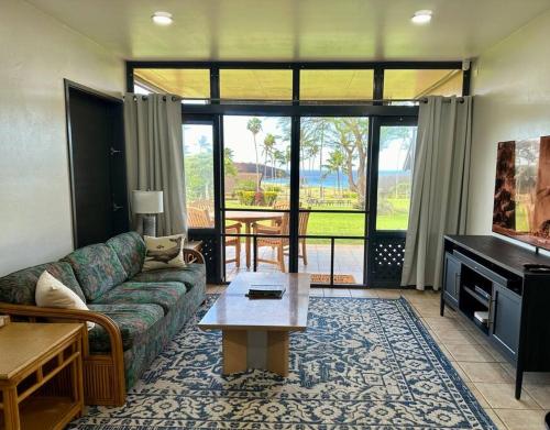 uma sala de estar com um sofá e uma mesa em Kepuhi Sunset Ocean View - Ground Floor Unit by Wrinkly Sheets, LLC em Maunaloa
