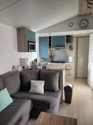 un salon avec un canapé et une cuisine dans l'établissement Mobil-home VI 52 à Vias - La Carabasse - Camping Siblu avec piscine, à Vias