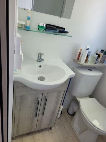 une salle de bain avec un lavabo blanc et des toilettes dans l'établissement Mobil-home VI 52 à Vias - La Carabasse - Camping Siblu avec piscine, à Vias