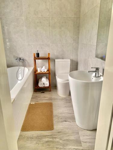 łazienka z wanną, umywalką i toaletą w obiekcie White House Residences w mieście Lusaka