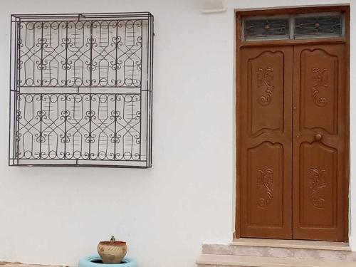 una puerta y un jarrón sentados junto a una pared en Appartement Chebbi, en Tozeur