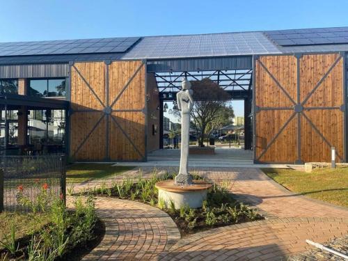 a building with two large wooden doors and a statue at Insaka Greenpark 2Bed Aptment-Boksburg in Boksburg