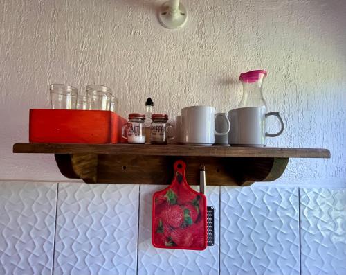 a shelf on the wall with cups and a jug at Cabanas MERALE Excelente Ubicacion in Puerto Iguazú