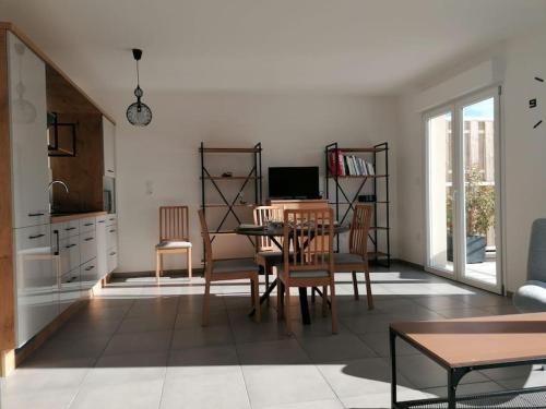 ein Wohnzimmer mit einem Tisch und einem Computer. in der Unterkunft Appartement avec Terrasse in Cléon-dʼAndran