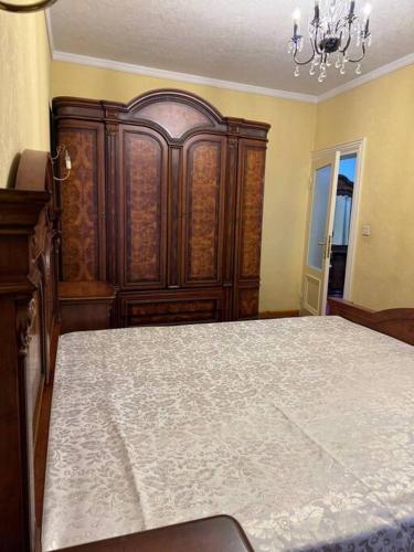 a bedroom with a large bed and a large wooden cabinet at Apartment in Samarkand